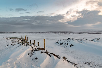 Scenic view of snow covered field against sky