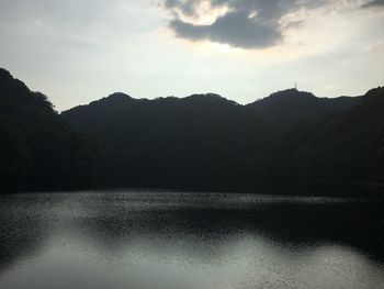 Scenic view of lake by mountains against sky