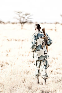 Rear view of man walking on field