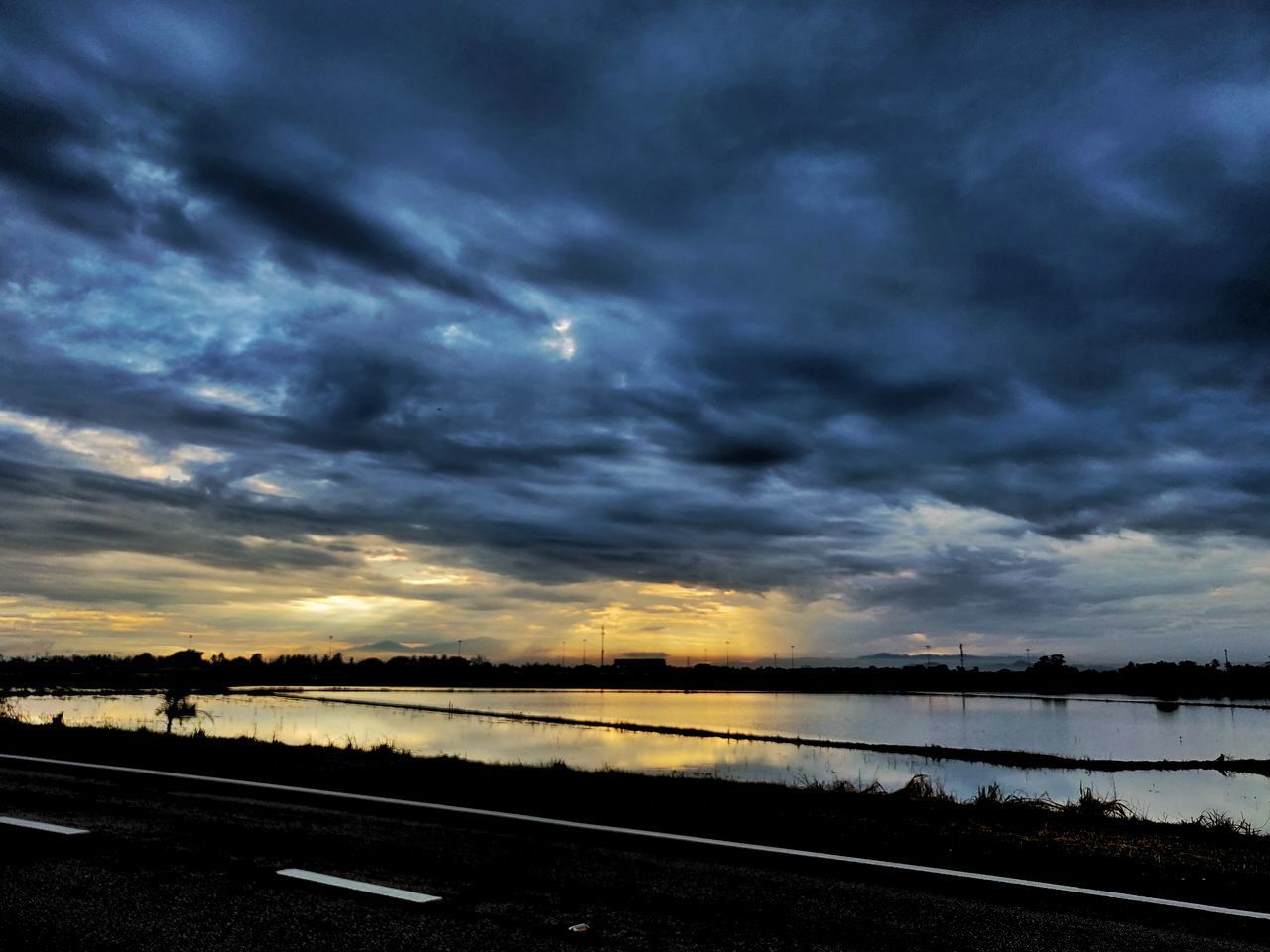 SCENIC VIEW OF ROAD AGAINST DRAMATIC SKY