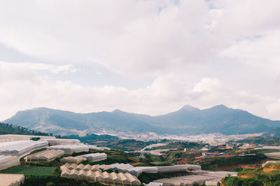 Aerial view of townscape by mountains against sky