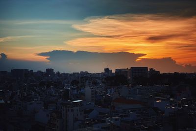 High angle view of silhouette buildings against sky during sunset