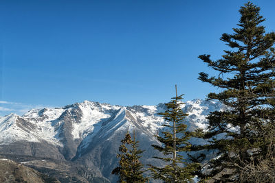 Scenic view of snowcapped mountains against clear blue sky