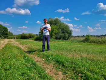 Full length of man standing on field against sky