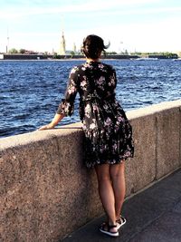 Rear view of woman standing against the sea