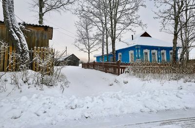 Houses on snow covered field by building