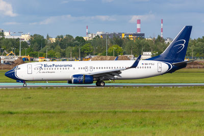 Side view of airplane on runway against sky