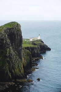 Rock formation by sea against sky