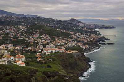 High angle view of townscape by sea against sky