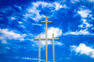 Low angle view of cross against blue sky