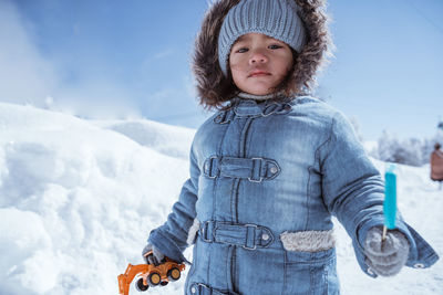 Portrait of young woman standing on snow