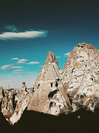 Scenic view of rock formation and buildings against sky