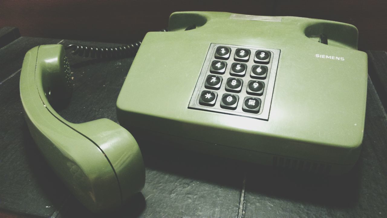 indoors, communication, technology, text, high angle view, close-up, number, table, connection, western script, retro styled, still life, no people, old-fashioned, wireless technology, telephone, single object, absence, green color, computer keyboard