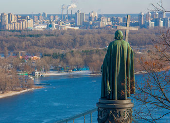 Rear view of statue against buildings in city