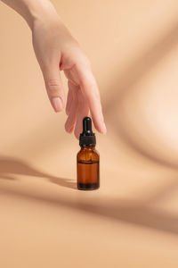 Close-up of hand holding electronic cigarette on table