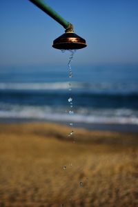 Close-up of water drop falling on beach