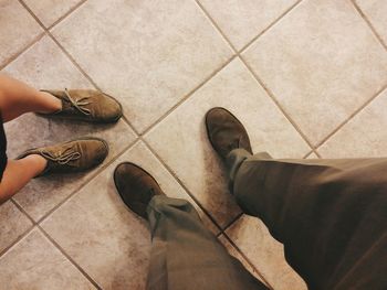 Low section of person standing on tiled floor