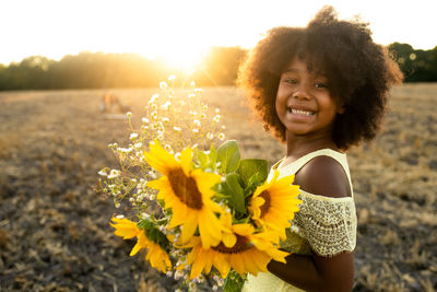 Portrait of smiling girl with yellow flower