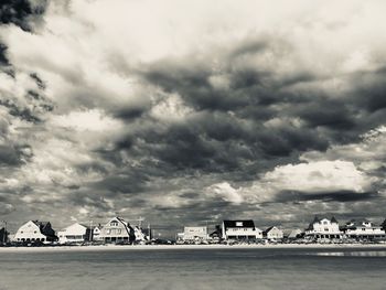 Scenic view of sea by buildings against sky