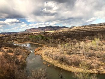 Scenic view of river and mountains against sky