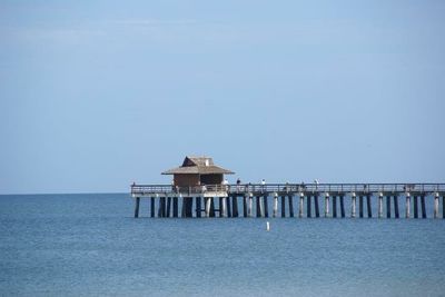 Built structure on pier over sea against clear sky