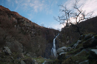 Scenic view of waterfall against sky