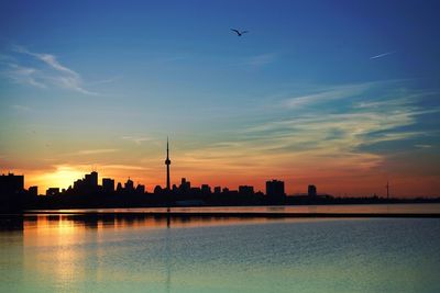 Silhouette tokyo sky tree and cityscape by river during sunrise