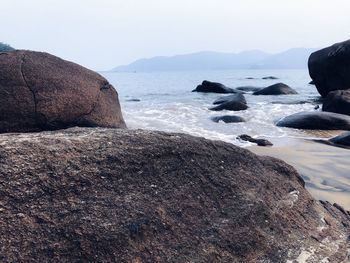 Rocks on beach against sky