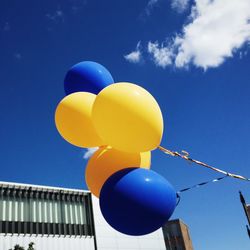 Low angle view of balloons against blue sky