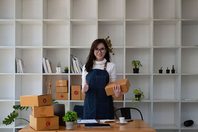 Portrait of young woman sitting on table