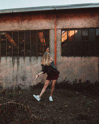 Side view of woman on window of abandoned building