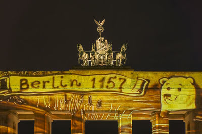 Low angle view of illuminated statue against sky at night