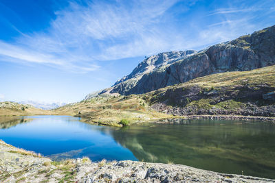 Scenic view of lake by mountains against sky