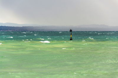 Rear view of woman standing on sea against sky