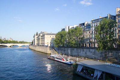 Bridge over river in city against sky