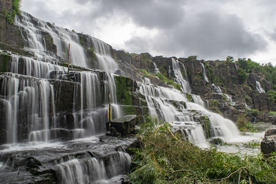 Scenic view of waterfall against sky