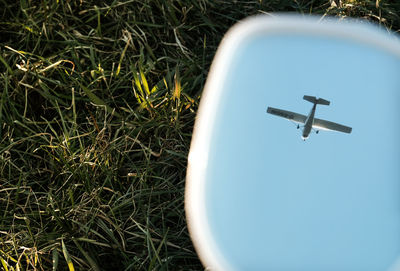 Reflection of airplane in water over field