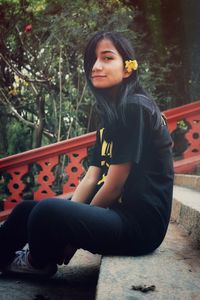 Beautiful young woman sitting in park