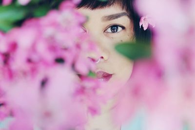 Close-up portrait of woman with pink flower