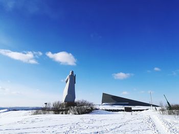 Snow covered field against blue sky