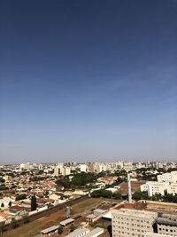 High angle view of buildings against clear blue sky