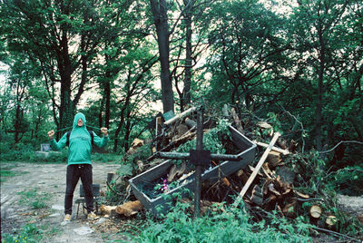 Man standing by trees in forest