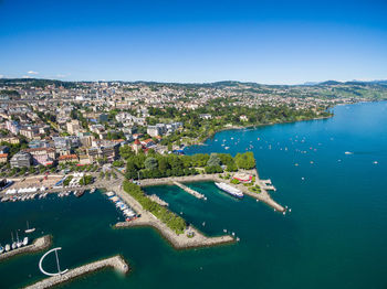 High angle view of buildings by sea against blue sky