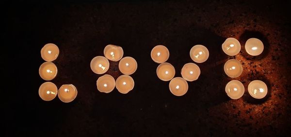 Close-up of illuminated candles on black background