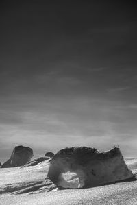 Scenic view of rocks on beach against sky