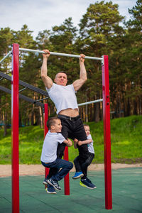 Rear view of father and son on daughter in park