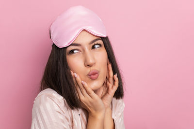 Portrait of young woman against yellow background