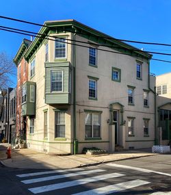 Street by buildings against blue sky