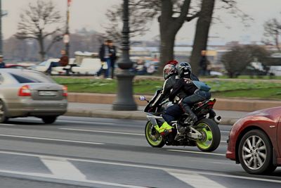 Man riding motorcycle on road in city