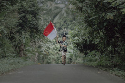 Kid running holding indonesian flag